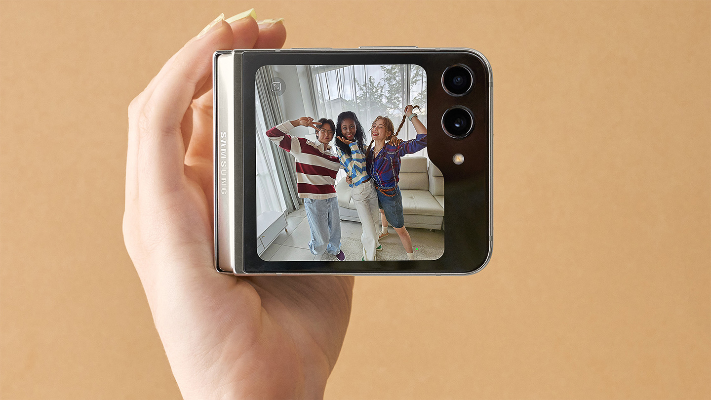 Galaxy Z Flip 5 fermé tenu en main, l'écran externe Flex Window affichant une photo